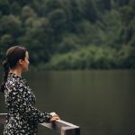 A serene moment of a woman enjoying nature by a peaceful forest lake in Türkiye.