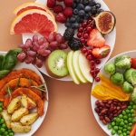 Top view of vibrant plates of fresh fruits and vegetables, perfect for a healthy lifestyle.